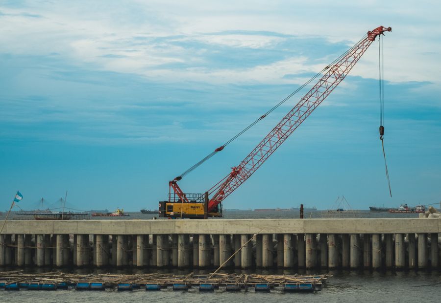 Marine crew rebuilding a seawall face along a Hampton Roads tidal river
