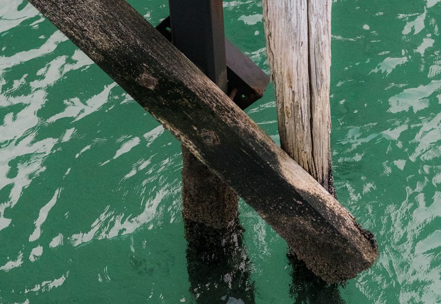 Timber tie-back and anchor system behind a tidal bulkhead